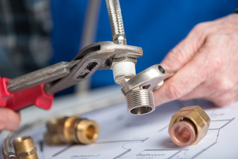 Plumber screwing a plumbing fitting